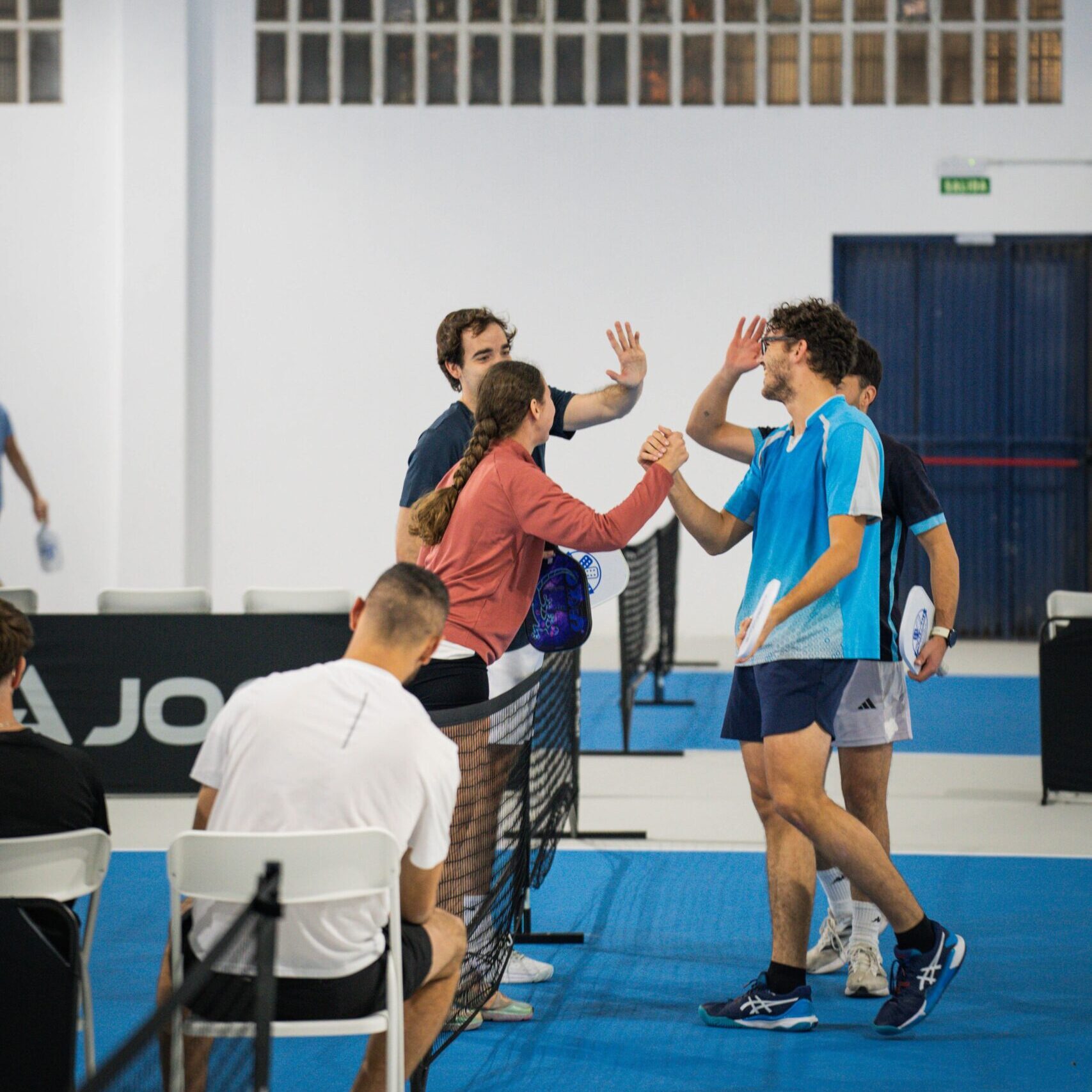 En la imagen se ve a los contrincantes chocando las manos con gran deportividad durante un partido en Club Pickleball Zaragoza