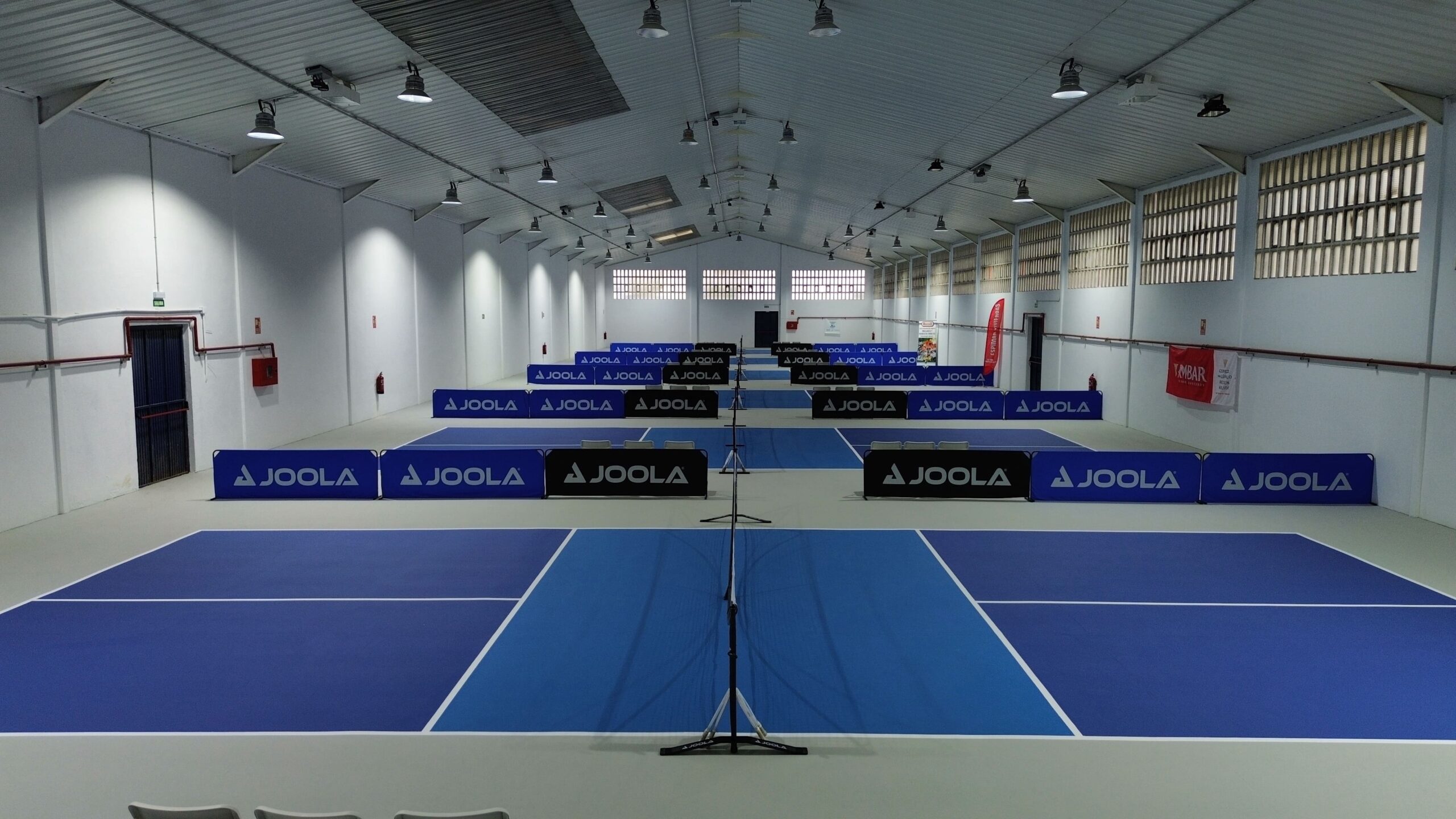 En la imagen se muestran la nave de Club Pickleball Zaragoza, unas grandes instalaciones con 7 pistas indoor